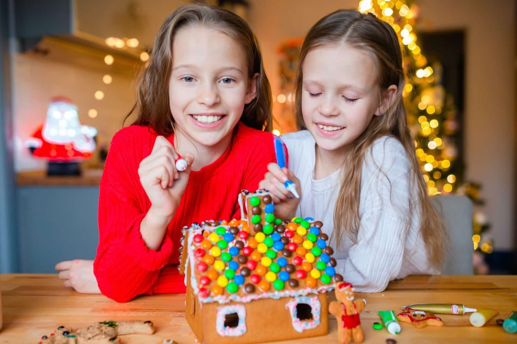 little-girls-making-christmas-gingerbread-house-in-the-kitchen.jpg