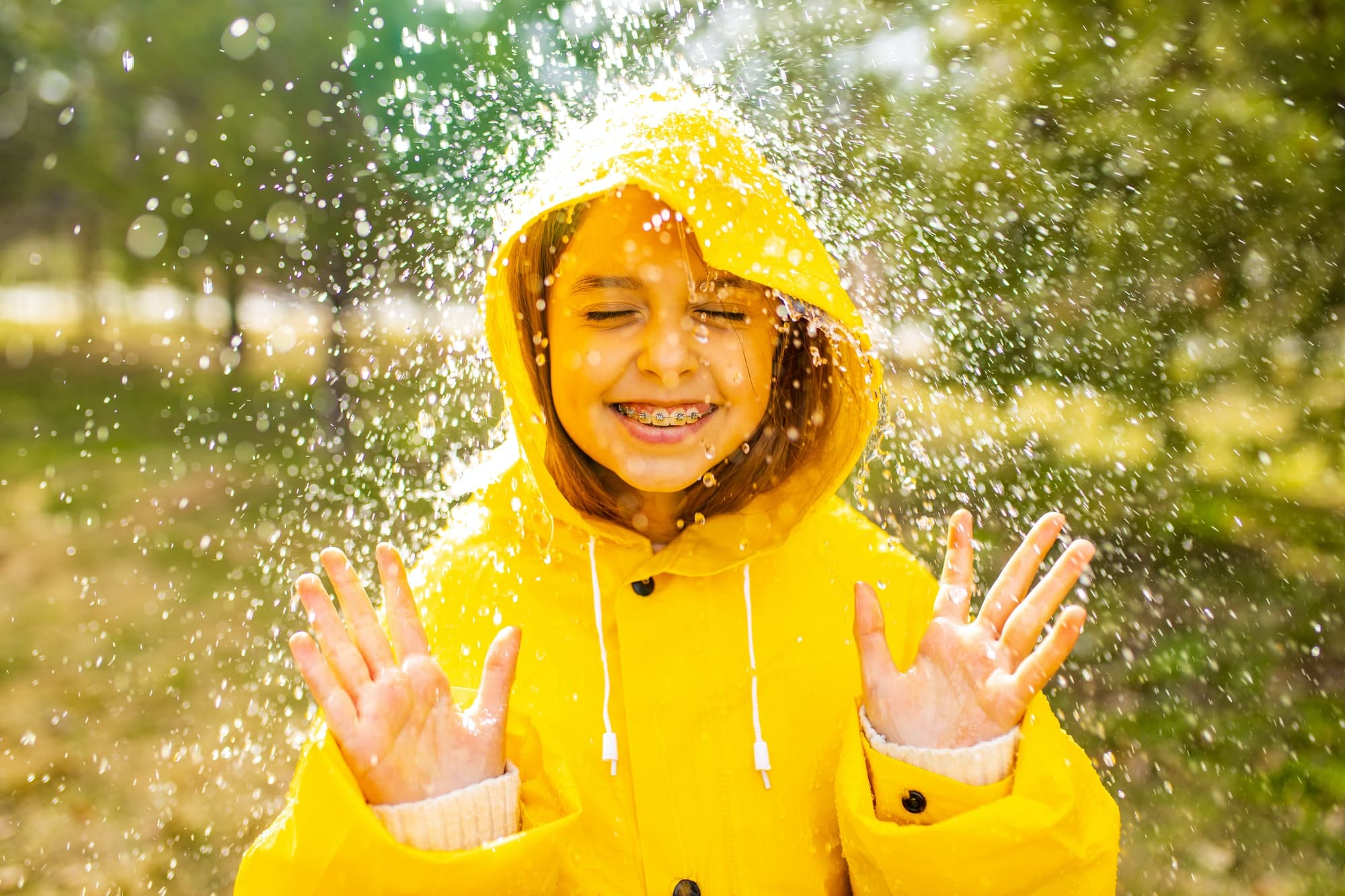 smiling-teenage-girl-wearing-raincoat-outdoors-in-rainy-day.jpg
